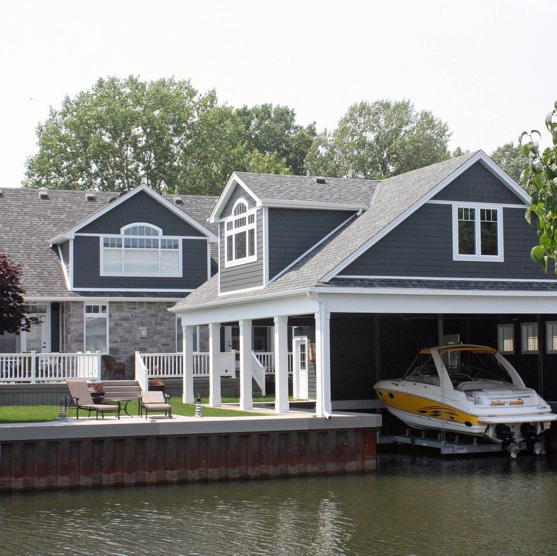 Shingle-style home with covered boat slip on the canal