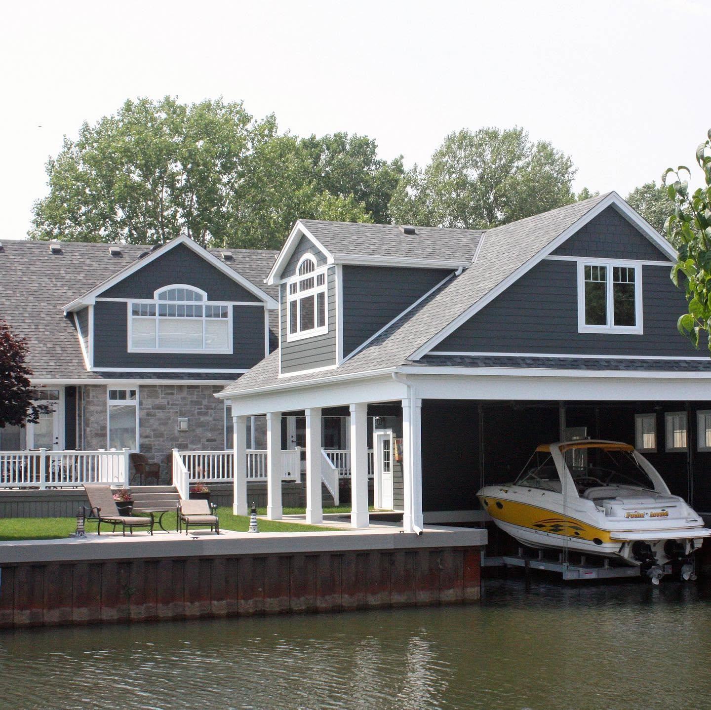 A Ross-built shingle-style home on the canal, boat moored beneath the porch
